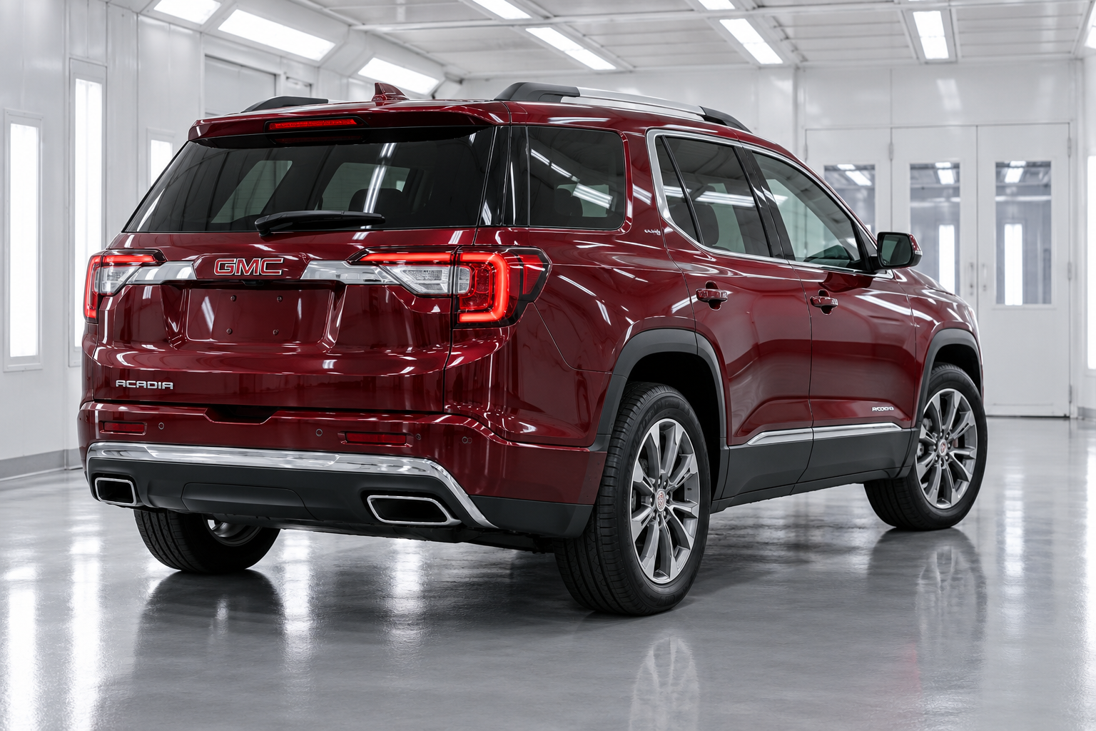 Promotional image of a burgundy GMC Acadia in a finishing bay